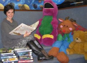 Callie bates on a couch with stuffed animals