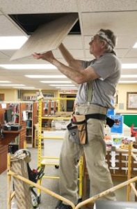 Man replacing ceiling tiles