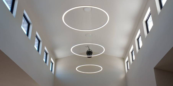 Ceiling with circular light fixtures and rectangular upper windows.