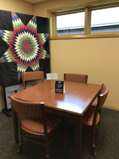 Manitowish River Room with 1 table and 4 chairs and a geometric design on one wall.